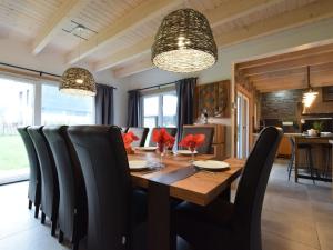 comedor con mesa de madera y sillas negras en Grandeur Villa with Sauna Jacuzzi in Durbuy en Durbuy