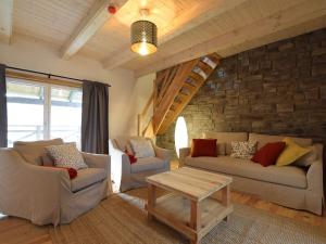 una sala de estar con 2 sofás y una pared de piedra. en Grandeur Villa with Sauna Jacuzzi in Durbuy en Durbuy