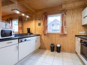 a kitchen with white cabinets and a microwave at Wooden chalet in Stadl an der Mur with sauna in Stadl an der Mur