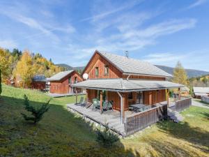 a large wooden house with a deck in a field at Wooden chalet in Stadl an der Mur with sauna in Stadl an der Mur