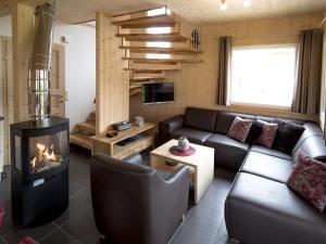 a living room with a couch and a fireplace at Charming Chalet in Sankt Georgen ob Murau on Ski Slopes in Sankt Lorenzen ob Murau