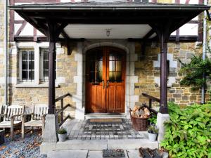 una puerta delantera de una casa de piedra con puerta de madera en Beautiful castle house in Spa with spacious garden, en Spa