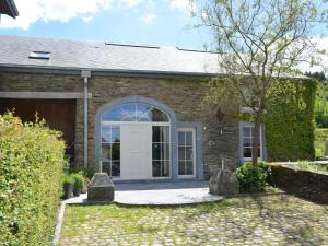 a brick house with a white door at Villa with hottub in calm area in Bièvre