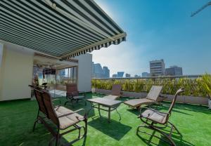 a patio with chairs and tables on a balcony at Suites Arquimedes 33 in Mexico City