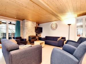 a living room with blue couches and a fireplace at Atmospheric chalet with sauna and jacuzzi in Septon