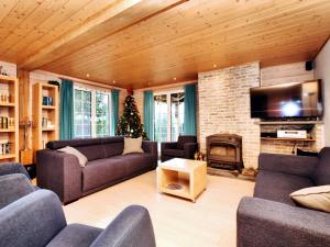a living room with couches and a fireplace and a christmas tree at Atmospheric chalet with sauna and jacuzzi in Septon