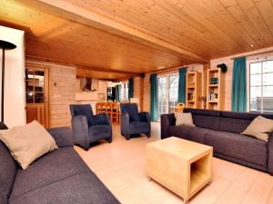 SeptonにあるAtmospheric chalet with sauna and jacuzziのリビングルーム(ソファ、椅子、テーブル付)