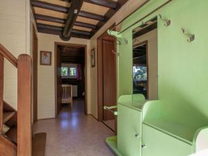 a hallway with green walls and stairs in a house at Open wooden chalet built against a hill in Francorchamps