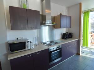 a kitchen with a microwave and a stove top oven at Lovely modern cottage with sauna bubble baths in Grand Coo