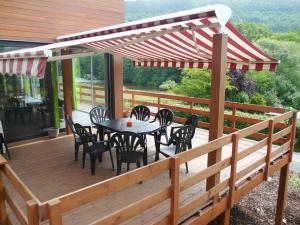 a patio with a table and chairs on a deck at Lovely modern cottage with sauna bubble baths in Grand Coo