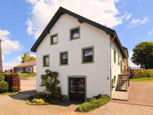 a white house with a black roof at Lovely Holiday Home in B tgenbach by the Lake in Butgenbach