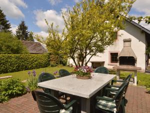 een tafel en stoelen in een tuin met een open haard bij Lovely Holiday Home in B tgenbach by the Lake in Butgenbach