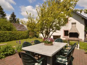 uma mesa e cadeiras num jardim com lareira em Lovely Holiday Home in B tgenbach by the Lake em Butgenbach