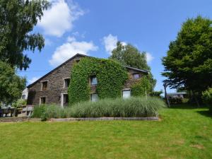 an ivy covered house with a lawn in front of it at Wonderful Holiday Home in Noirefontaine in Bouillon