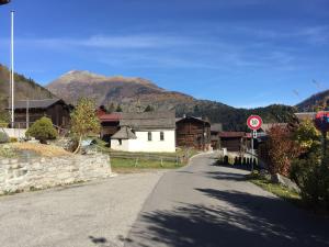 un camino vacío en un pueblo con montañas en el fondo en Attractive chalet in Fiesch Wiler with views, en Fiesch