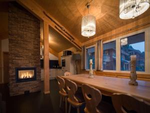 a dining room with a fireplace and a wooden table at Chalet Alpenpark Turracherhöhe 1 in Turracher Hohe