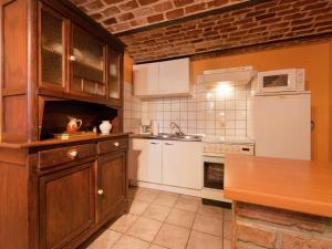 a kitchen with white appliances and a brick wall at Farmhouse situated at the edge of the woods in Manhay