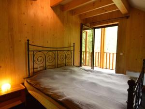 a bedroom with a bed in a room with a window at Comfortable modern chalet with wood finish in Aywaille