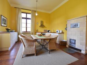 GerdshagenにあるModern Apartment in Satow with Gardenの黄色の壁のキッチン(テーブル、椅子付)