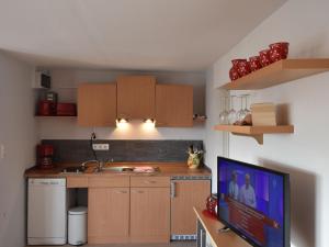 シュテルンベルクにあるClassy Holiday Home in Sternberg with Jettyのキッチン(木製キャビネット、薄型テレビ付)