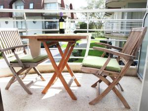 a wooden table and two chairs on a porch at Stylish Apartment in Bredene with Pool in Bredene