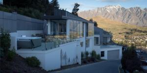 une maison sur une colline avec des montagnes en arrière-plan dans l'établissement Views on Edinburgh, a Relax it's Done luxury holiday home, à Queenstown