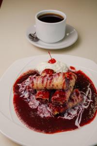 a plate of food with a red sauce and a cup of coffee at Hotel Palacio in Córdoba