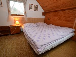 a bedroom with a large bed in a room with a window at small holiday home at the edge of the forest in Malá Skála