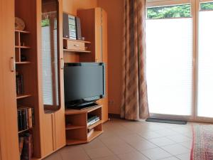 uma sala de estar com televisão e uma estante de livros em Cosy Holiday Home in Dorf Gutow near the Sea em Dorf Gutow