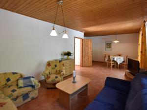 a living room with a blue couch and a table at Country holiday home in Damshagen with sauna in Damshagen