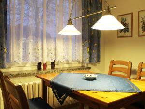 ein Esszimmer mit einem Tisch und zwei Leuchten in der Unterkunft Seaside Bungalow with Terrace, Garden, Barbecue, Parking in Insel Poel