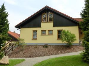 ein gelbes Haus mit schwarzem Dach in der Unterkunft Pleasant Holiday Home With Terrace in Schirgiswalde Germany in Schirgiswalde