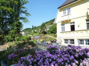 a garden in front of a house with purple flowers at Villa with a view of the Weserbergland in Bad Pyrmont