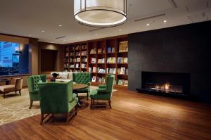 a living room with a fireplace and green chairs at Shiba Park Hotel in Tokyo