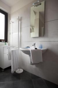 y baño con lavabo, espejo y toallas. en Villetta Martinelli, en Nago-Torbole