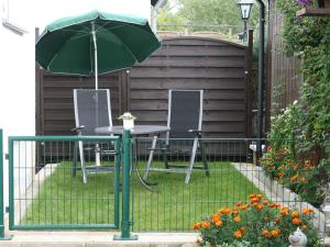 a table and chairs with an umbrella in a backyard at Apartment near the Nurburgring with terrace in Hillesheim
