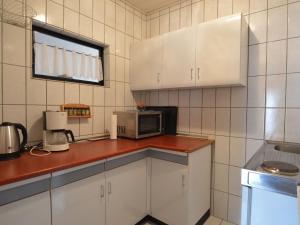 トリッテンハイムにあるScenic Apartment in Trittenheim with Gardenのキッチン(白いキャビネット、電子レンジ付)