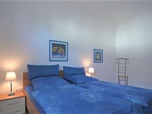MadfeldにあるTasteful apartment in Brilon with terraceのベッドルームの青いベッド1台(青いシーツ付)
