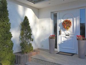 a blue door with a wreath on it next to plants at Ferienwohnung in Madfeld nahe Wald in Madfeld