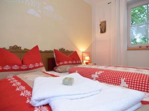 1 dormitorio con 2 camas y toallas rojas y blancas en Holiday home in Halblech near a ski resort, en Halblech