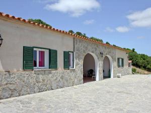 アス・マルカダルにあるBelvilla by OYO Canyar Enzellの緑の鎧戸付きの石造りの建物
