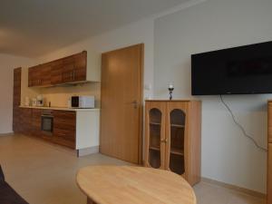 a living room with a table and a tv on a wall at Modern Apartment in Eifel near Forest in Dohm-Lammersdorf