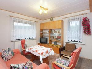 a living room with a couch and a table at Appealing holiday home in Altenfeld with terrace in Altenfeld