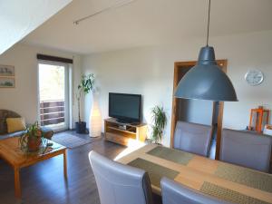 ein Esszimmer mit einem Tisch und einem TV in der Unterkunft Apartment in the middle of Franconian Switzerland in Kunreuth