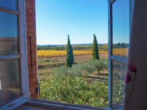 uma janela com vista para um campo e árvores em Spacious 6 person villa with pool em Autignac