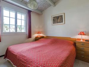 a bedroom with a red bed and two windows at Modern holiday home with swimming pool in Peymeinade