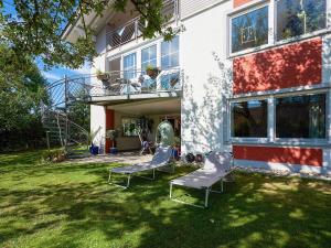 two chairs sitting in the yard of a house at Nice flat with sauna covered terrace garden and tree house for children in Zandt