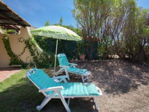 two lounge chairs and an umbrella in a yard at Romantic Retreat in Cargèse in Cargèse