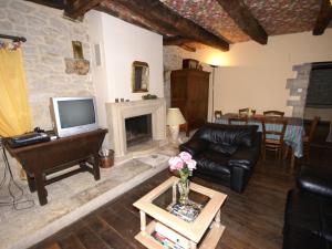 a living room with a couch and a fireplace at Cosy holiday home with garden in Saint-Geniez-dʼOlt