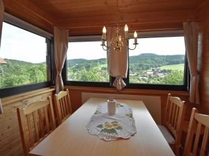 a dining room with a table and two large windows at Holiday home with private garden in Waltershausen